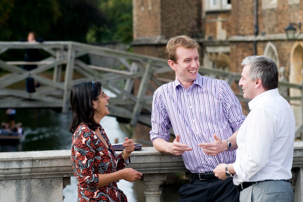 Cambridge Executive MBA participants networking by the River Cam and the historic Mathematical Bridge, Queens' College